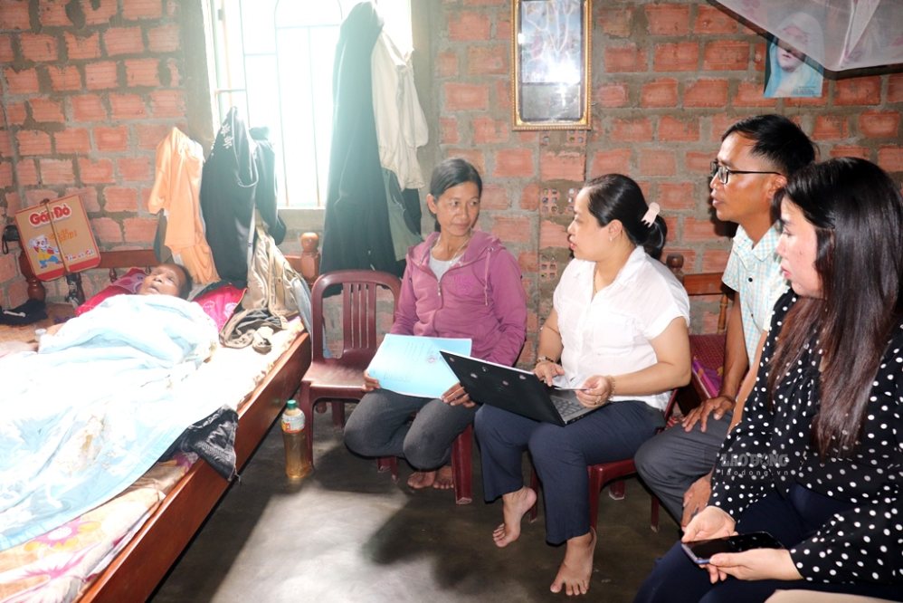 Con gái ông A Pheng (áo đỏ) đang làm thủ tục chuẩn bị mừng thôn 95 tuổi cho cha. Ảnh: Lâm Hiền 