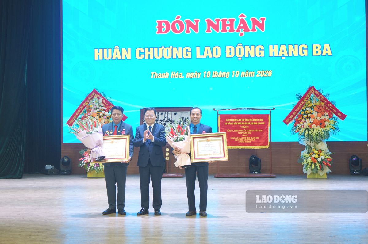Chủ tịch Tổng LĐLĐ Việt Nam Nguyễn Anh Tuấn trao Huân chương hạng Ba và tặng hoa chúc mừng 2 cá nhân có thành tích xuất sắc. Ảnh: Quách Du (chụp ngày 10.10.2026)
