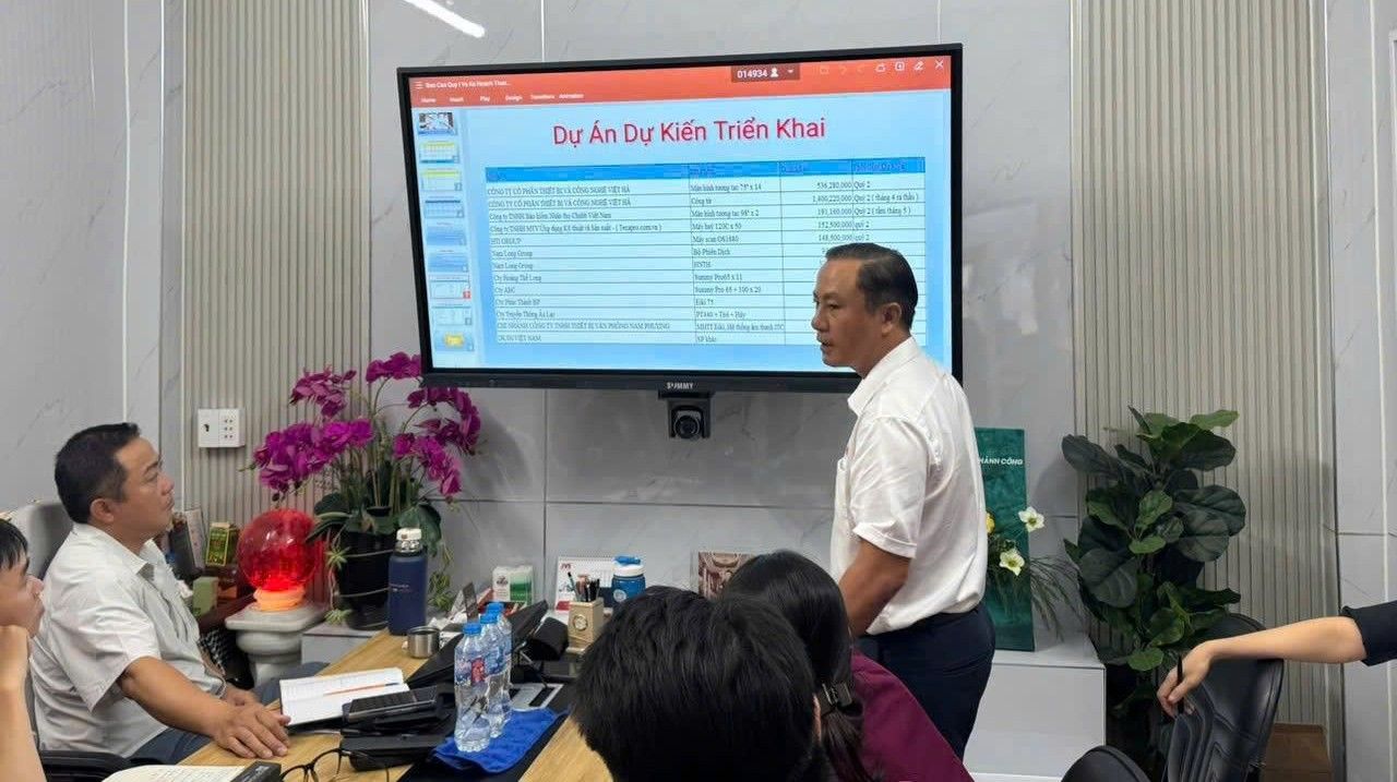 Tại phòng họp thông minh, ông Trần Duy Đông - Chủ tịch Công đoàn Công ty JVS (áo trắng bìa trái) trao đổi với nhân viên trực tiếp trên màn hình tương tác. Ảnh: Công đoàn công ty JVS