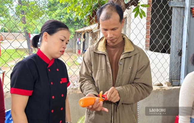 Anh Lưu Quang Dũng thực hành cắt tỉa cà rốt dưới sự hướng dẫn của cô giáo Nguyễn Thị Luận tại lớp học nấu ăn ở thôn A Ngo (ảnh chụp tháng 9.2026). Ảnh: Hưng Thơ