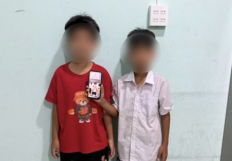 Hai em nhỏ giao nộp điện thoại nhặt được cho Công an xã Phan Rí Cửa. Ảnh: Công an cung cấp (chụp tháng 10.2026).