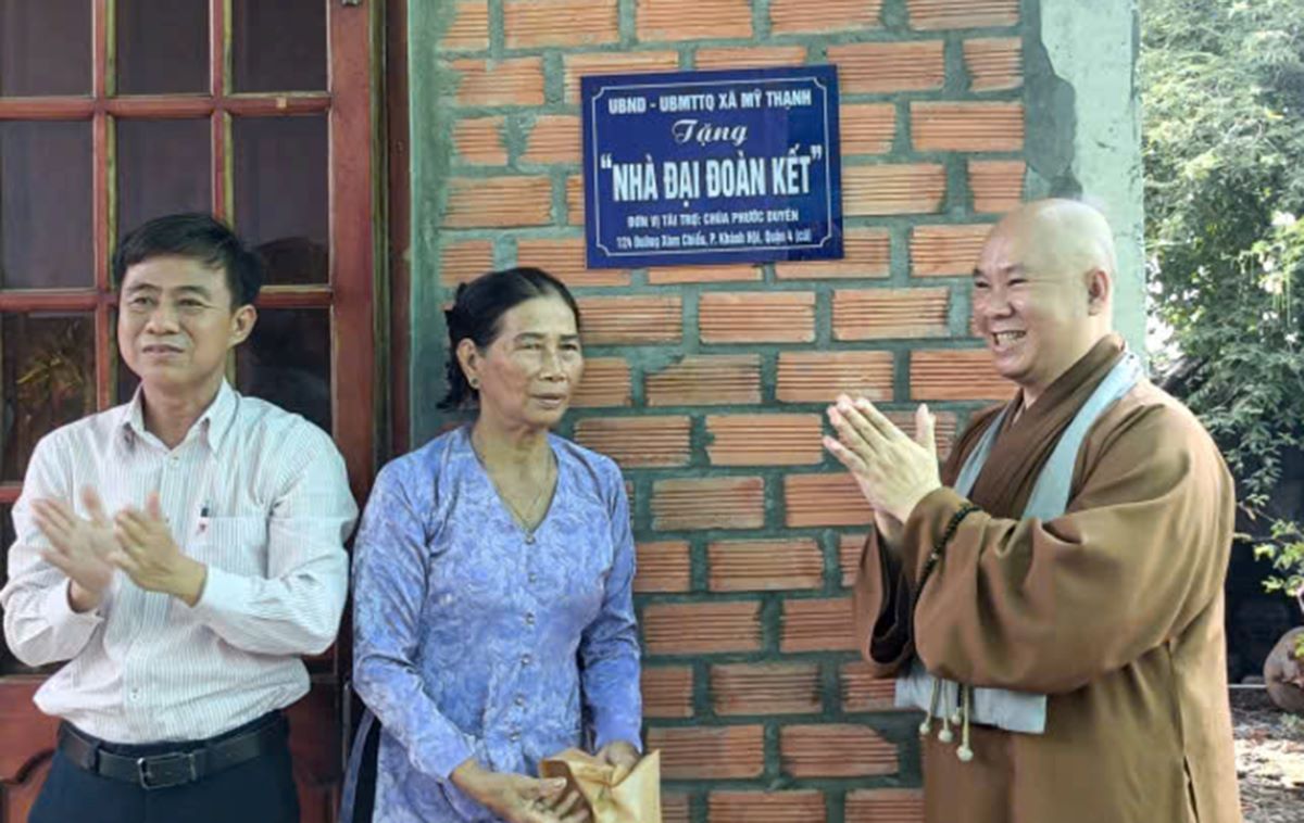Lãnh đạo UBND xã Mỹ Thạnh, tỉnh Tây Ninh cùng đại diện chư Tăng Chùa Phước Duyên gỡ băng bàn giao nhà Đại đoàn kết cho bà Danh. Ảnh: Phật giáo Tây Ninh ngày 11.10