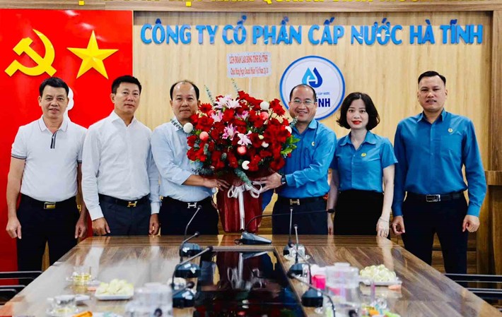 Ông Nguyễn Thế Hoàn - Chủ tịch LĐLĐ tỉnh Hà Tĩnh tặng hoa chúc mừng Công ty CP Cấp nước Hà Tĩnh. Ảnh: Công đoàn Hà Tĩnh
