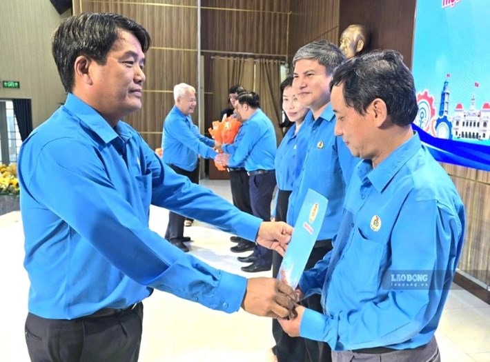Ông Bùi Thanh Nhân - Chủ tịch LĐLĐ TPHCM (trái) - trao quyết định thành lập các Công đoàn khu công công nghiệp cho các cán bộ công đoàn sáng 13.10. Ảnh: Nam Dương