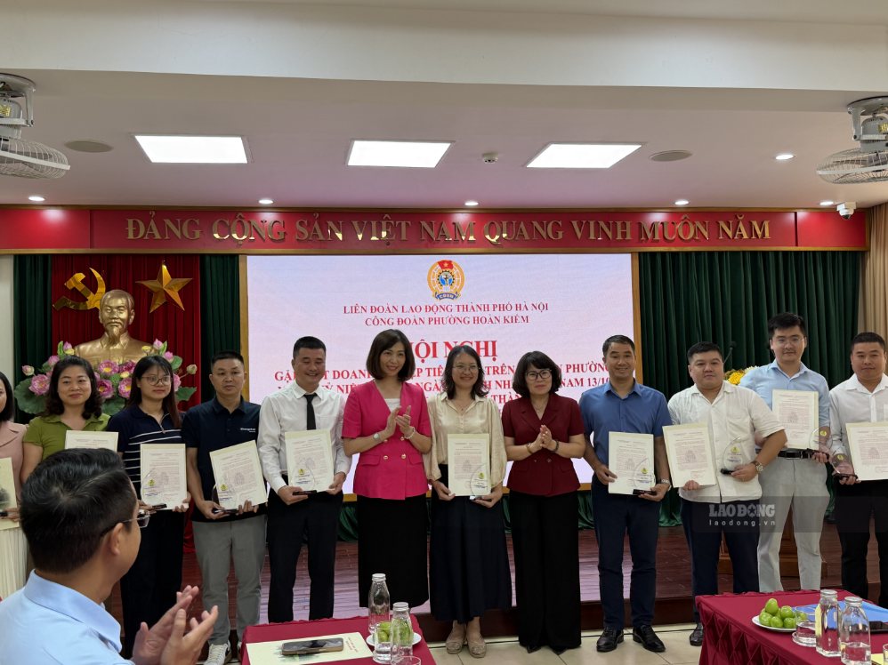 Trương Thị Thanh Nhàn - Phó Bí thư Thường trực Đảng ủy, Chủ tịch Hội đồng Nhân dân phường (áo hồng) và lãnh đạo phường chúc mừng các doanh nghiệp tiêu biểu năm 2026. Ảnh: Kiều Vũ
