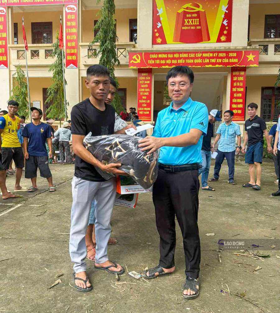 Nhà báo Trần Quang Đại - phóng viên Báo Lao Động, đại diện Quỹ Xã hội từ thiện Tấm lòng Vàng trao quà hỗ trợ người dân bị ảnh hưởng bởi lũ lụt. Ảnh: Duy Chương chụp tháng 7.2025