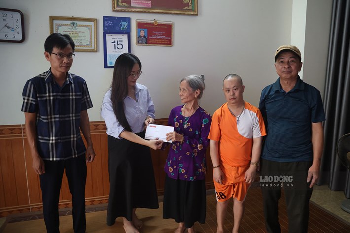 Đại diện Quỹ xã hội từ thiện Tấm lòng Vàng - Báo Lao Động trao số tiền hỗ trợ gia đình bà Văn Thị Lý. Ảnh: Dương Anh