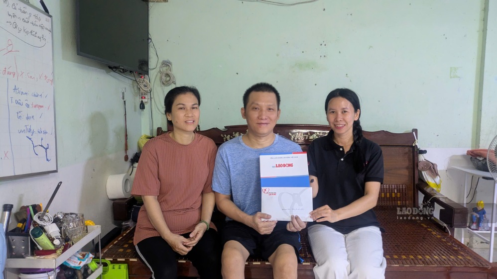 Vợ chồng anh Trần Lê Hữu Hiền nhận tiền hỗ trợ từ Quỹ Xã hội từ thiện Tấm Lòng Vàng của Báo Lao Động. Ảnh: Anh Tú