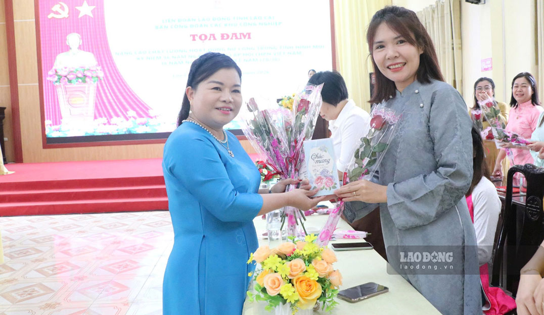 Ban tổ chức trao tặng hoa chúc mừng chị em nhân dịp Ngày Phụ nữ Việt Nam 20.10. Ảnh: Mạnh Hùng