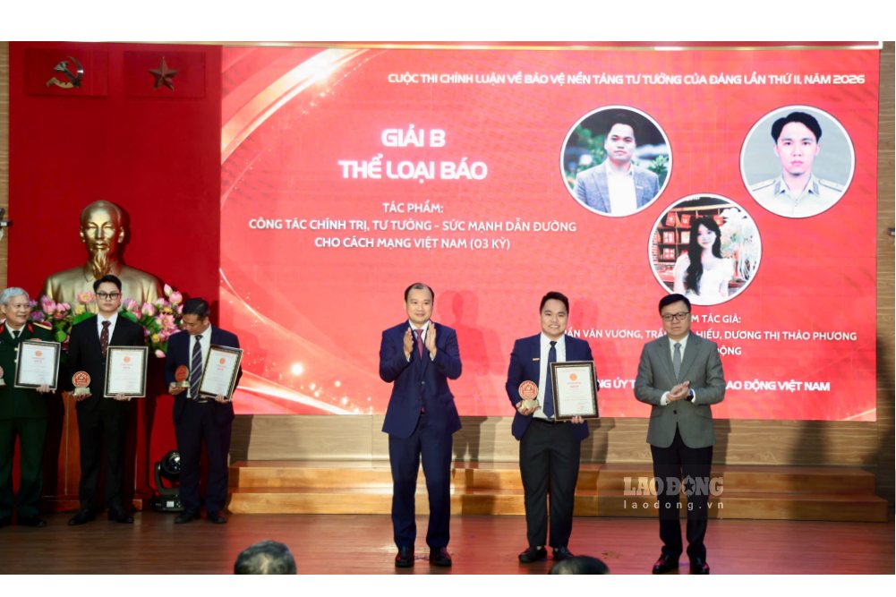 Ông Lê Hải Bình, Ủy viên Trung ương Đảng, Phó Giám đốc Thường trực Học viện Chính trị quốc gia Hồ Chí Minh và ông Lê Quốc Minh, Ủy viên Trung ương Đảng, Phó Trưởng Ban Tuyên giáo Trung ương, Tổng Biên tập Báo Nhân Dân, Chủ tịch Hội Nhà báo Việt Nam trao giải B cho đại diện nhóm tác giả đoạt giải của Báo Lao Động. Ảnh: Việt Anh