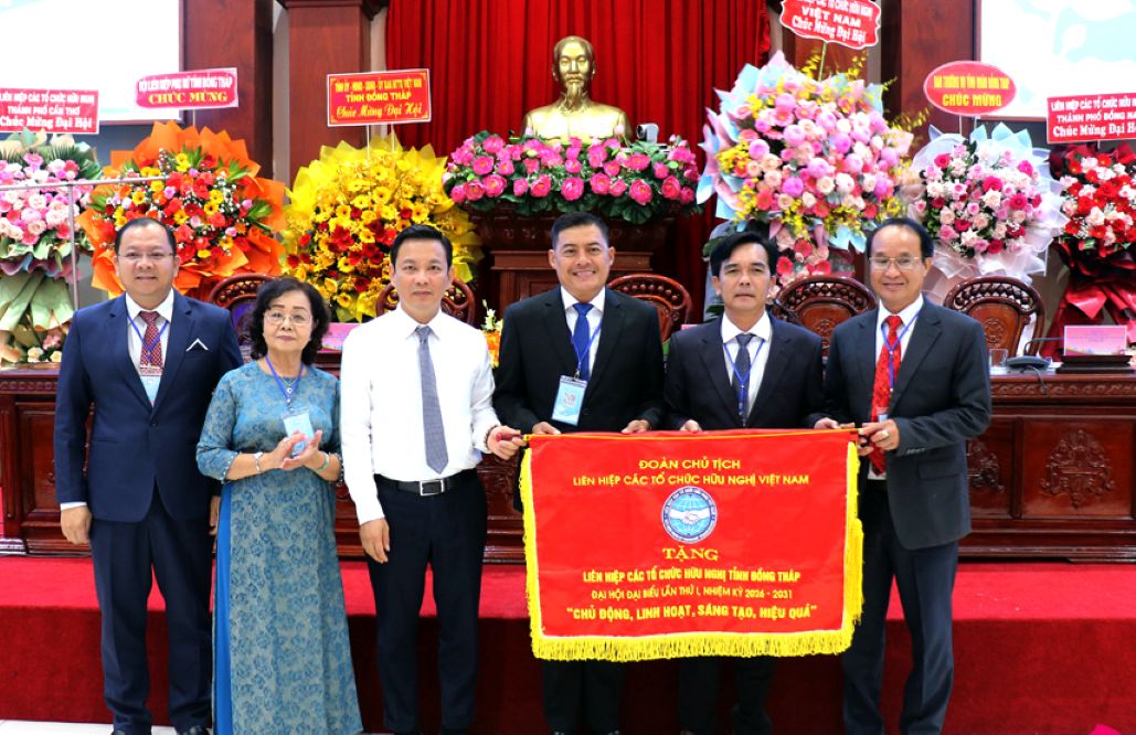 Ông Đồng Huy Cương - Phó Chủ tịch Liên hiệp các tổ chức hữu nghị Việt Nam tặng Liên hiệp các tổ chức hữu nghị tỉnh Đồng Tháp Cờ lưu niệm với phương châm “Chủ động thích ứng, đột phá sáng tạo, thiết thực hiệu quả”. Ảnh: Dongthap.gov.vn