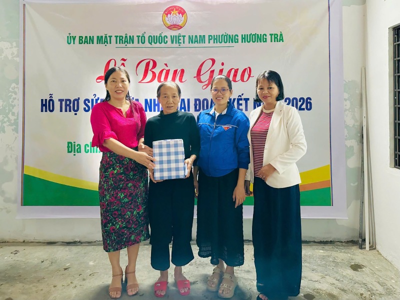 Các đoàn thể địa phương trao quà, động viên gia đình bà Nguyễn Thị Niệm tại lễ bàn giao nhà Đại đoàn kết. Ảnh: Mặt trận Hương Trà