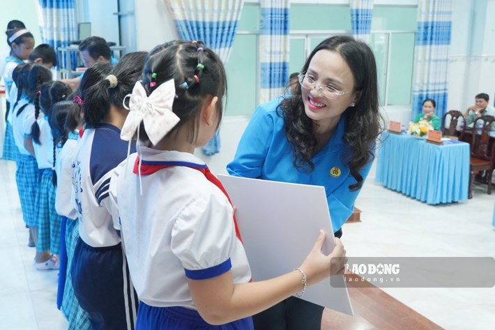 Bà Lê Thị Sương Mai - Chủ tịch LĐLĐ TP Cần Thơ trao học bổng cho các em học sinh. Ảnh: Tạ Quang
