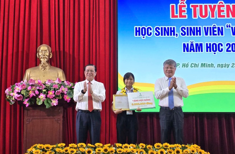 Ông Trần Công Kha - Chủ tịch HĐQT VRG (bên phải) và ông Lê Thanh Hưng - Tổng Giám đốc VRG (bên trái) - trao học bổng cho các học sinh, sinh viên tiêu biểu. Ảnh: Nam Dương