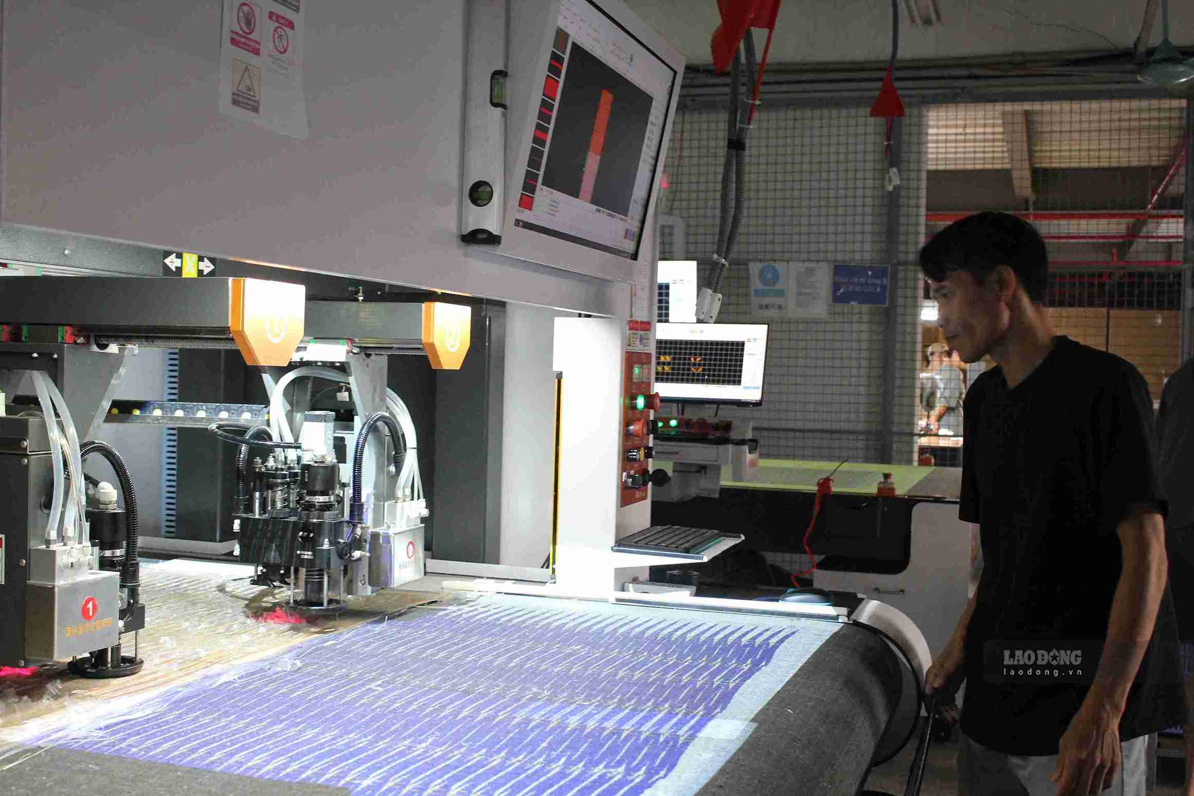 Anh Nguyễn Đình Ý vận hành máy cắt tự động ứng dụng công nghệ trong sản xuất. Ảnh chụp 24.10. Ảnh: Mai Hương