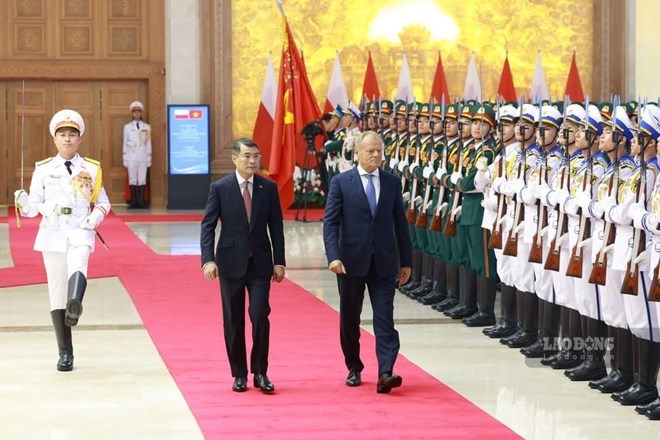 El miembro del Buró Político, Primer Ministro Lê Minh Hưng y el Primer Ministro de la República de Polonia Donald Tusk revisan el Equipo de Honor del Ejército Popular de Vietnam. Foto: Hải Nguyễn