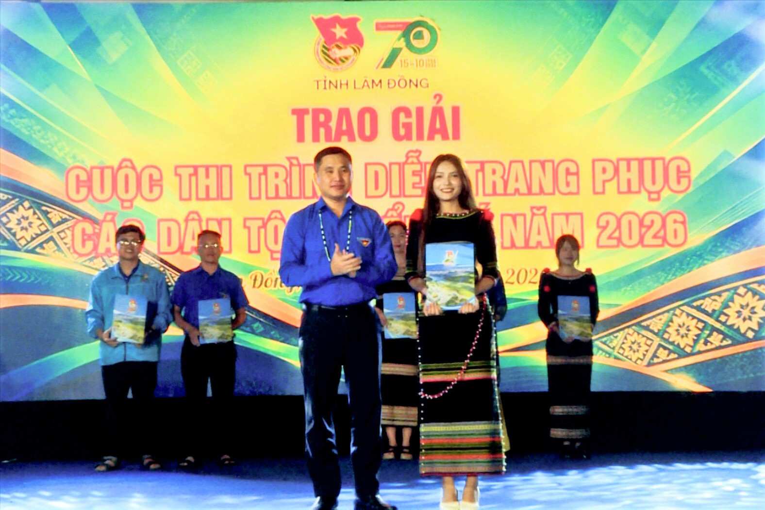 Ban Tổ chức trao giải Nhất phần trình diễn trang phục truyền thống cho đội thi xuất săc. Ảnh: Quang Vũ 