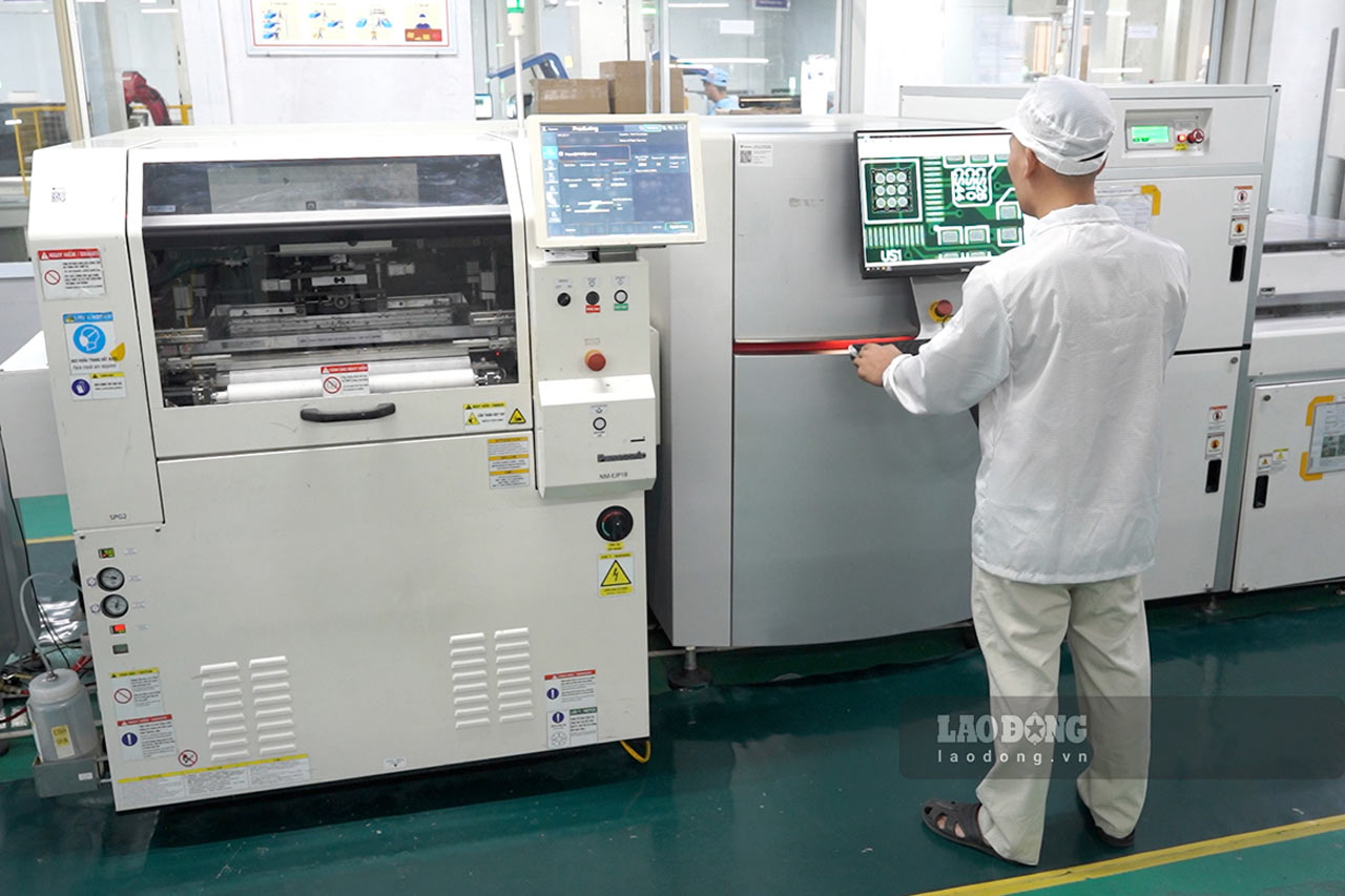 Anh Nguyễn Việt Tùng vận hành dây chuyền sản xuất bo mạch điện tử có cấu tạo phức tạp. Ảnh: Vũ Linh