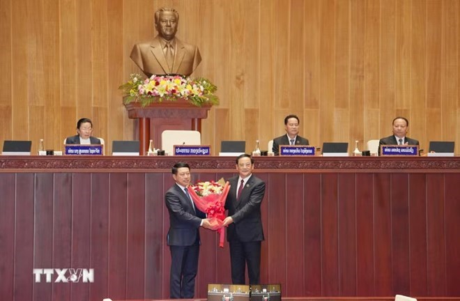 Chủ tịch Quốc hội Lào khóa X Sonexay Siphandone (phải) tặng hoa chúc mừng Thủ tướng Chính phủ Lào khóa X Saleumxay Kommasith. Ảnh: Xuân Tú/TTXVN