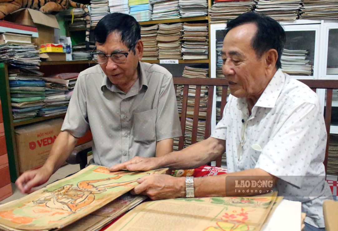 Nhà báo Trương Thanh Nhã (phải ảnh) trao đổi thông tin với đồng nghiệp tại căn phòng lưu trữ báo chí. Ảnh: Thanh Mai