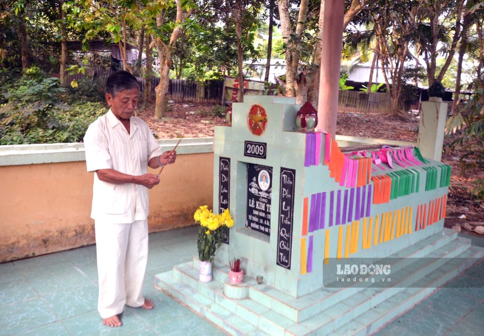 Ông Lê Trường Giang, con trai đầu lòng thắp hương lên mộ cha- cố nhà báo Lê Trắc - tọa lạc dưới vườn cây xanh mát do chính ông trồng lúc sinh thời. Ảnh: Thanh Mai (Ảnh chụp trước thời điểm 1.7.2025) 