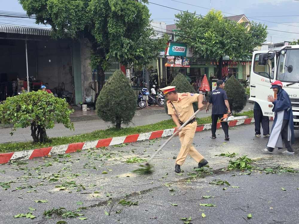 Cảnh sát giao thông dọn cây ngã đổ, thông đường cho người dân đi lại