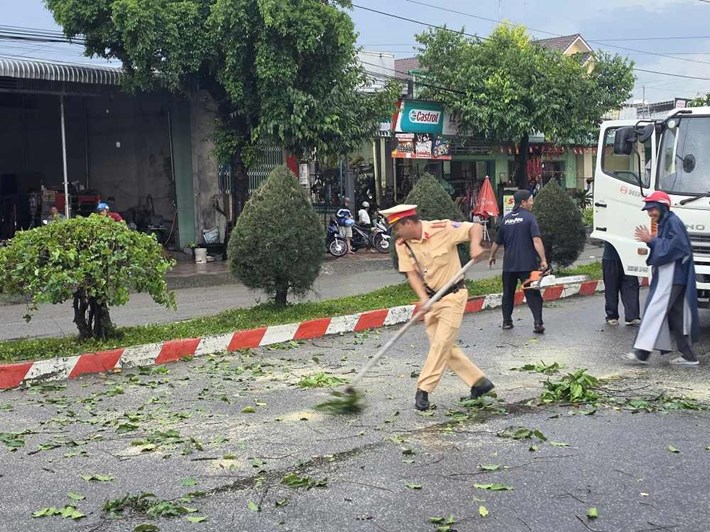 Tổ Cảnh sát Giao thông Đức Linh phối hợp dọn dẹp cây xanh ngã đổ trên đường tỉnh lộ 766 cho người dân lưu thông an toàn. Ảnh: Phòng Cảnh sát Giao thông Lâm Đồng