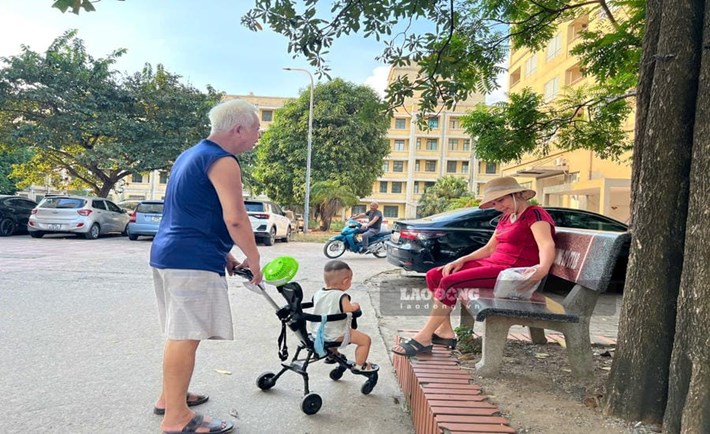 Dưới sân chơi chung của khu nhà ở công nhân Kim Chung (xã Thiên Lộc, Hà Nội) không khó để bắt gặp hình ảnh những ông bà trông cháu cho các con đi làm. Ảnh: Minh Phương