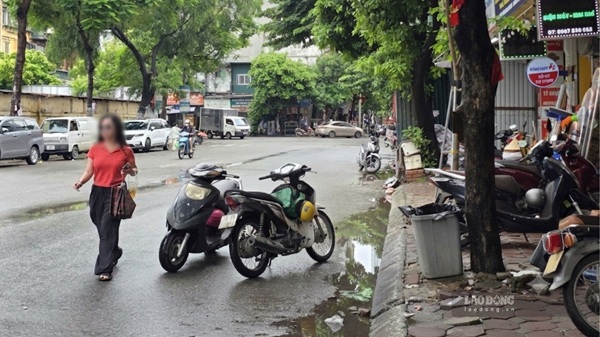 Xe máy đỗ trên vỉa hè, lòng đường trước cửa một quán ăn tại 271 Doãn Kế Thiện, Hà Nội. Ảnh: Minh Hạnh chụp 12h10 ngày 29.7.
