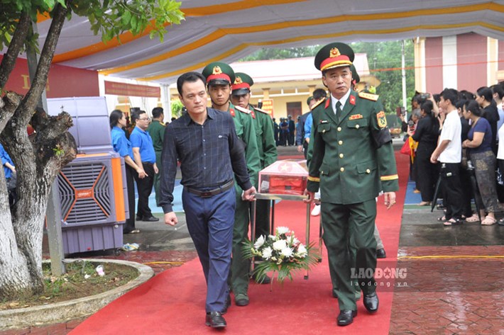 Lực lượng chức năng tỉnh Lào Cai đưa hài cốt liệt sĩ về nơi an nghỉ cuối cùng. Ảnh: Đinh Đại