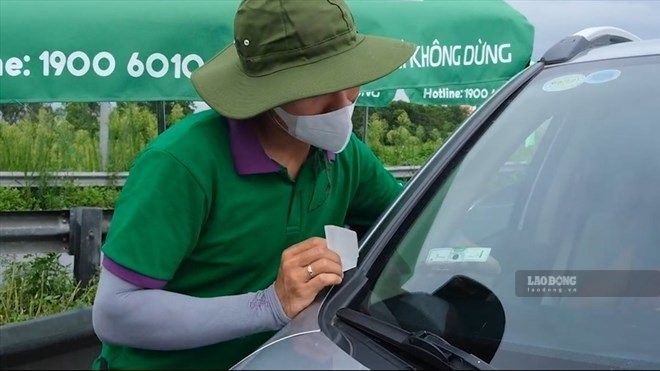 Dán thẻ thu phí không dừng VETC. Ảnh: Minh Ánh.