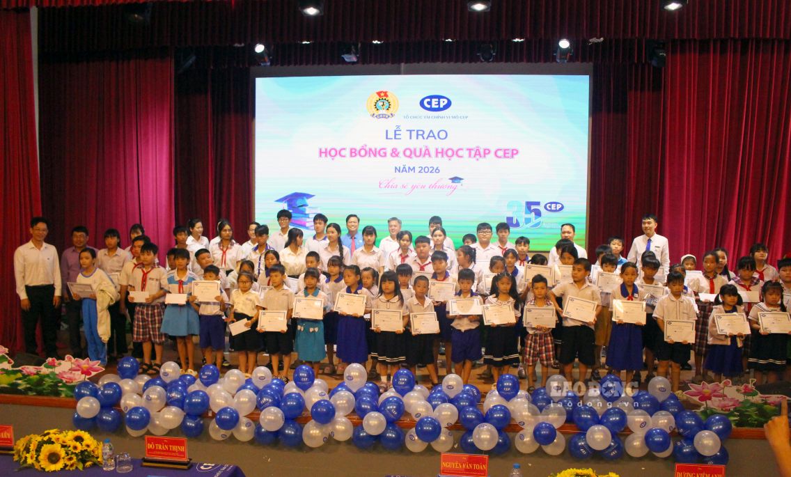 Ban tổ chức và phụ huynh, học sinh nhận học bổng, quà học tập chụp ảnh lưu niệm. Ảnh: Thanh Mai