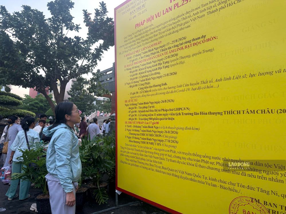 Kết thúc buổi cầu siêu, chị Vân lặng lẽ đứng ở một góc xem thông tin về tổ chức lễ Vu Lan. Ảnh: Minh Tâm