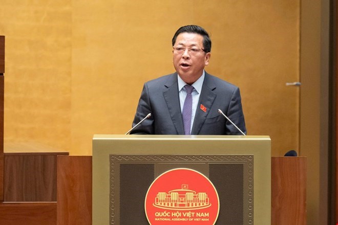 쩐홍민 당 중앙위원회 위원 겸 건설부 장관이 건축법 일부 조항 수정 및 보충에 관한 법률에 대한 국회의원들의 의견을 수렴하고 설명하는 보고서를 발표하고 있습니다. 사진: Quochoi. vn