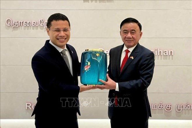 Ủy viên Bộ Chính trị, Thường trực Ban Bí thư Trần Cẩm Tú và Chủ tịch Đảng Hành động Nhân dân Singapore Desmond Lee trao tặng phẩm. Ảnh: TTXVN