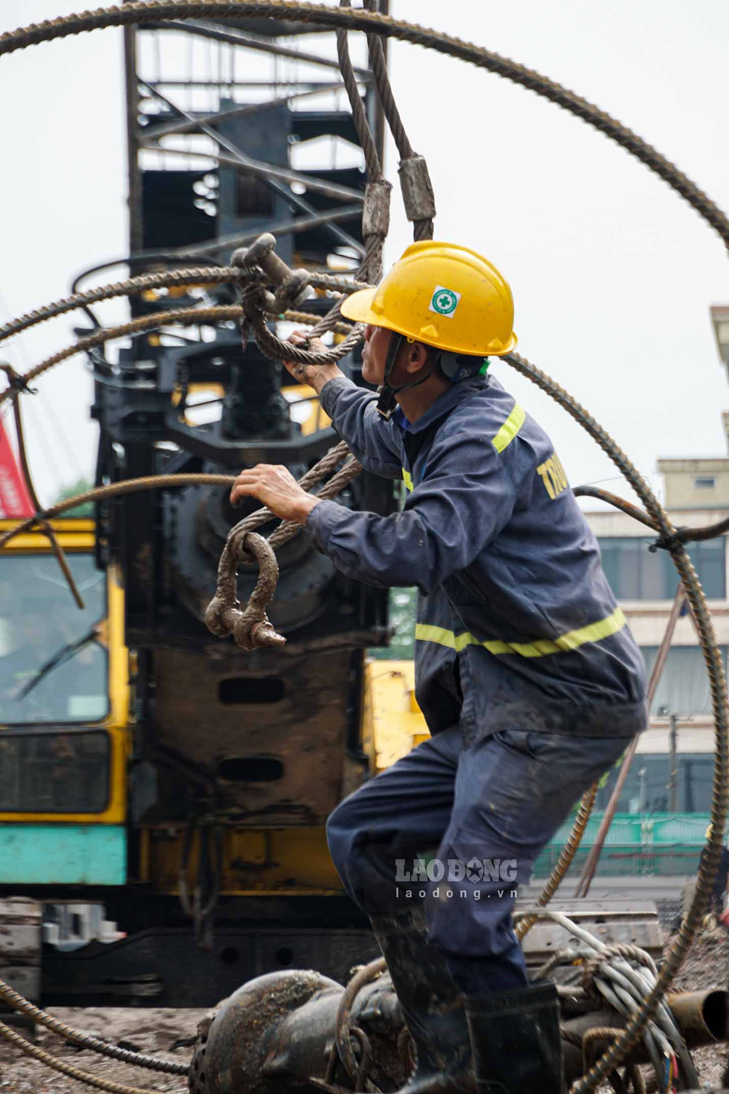 Trên công trường, các công nhân cùng nhiều máy móc hoạt động liên tục. 