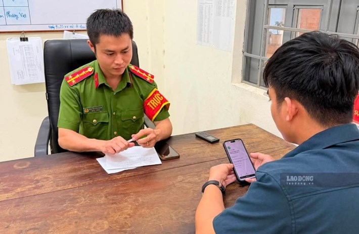 Công an xã Cửa Tùng hướng dẫn anh Tùng Sơn trả lại tiền cho chủ sở hữu sau khi nhận tiền từ tài khoản của người lạ. Ảnh: Văn Hưng