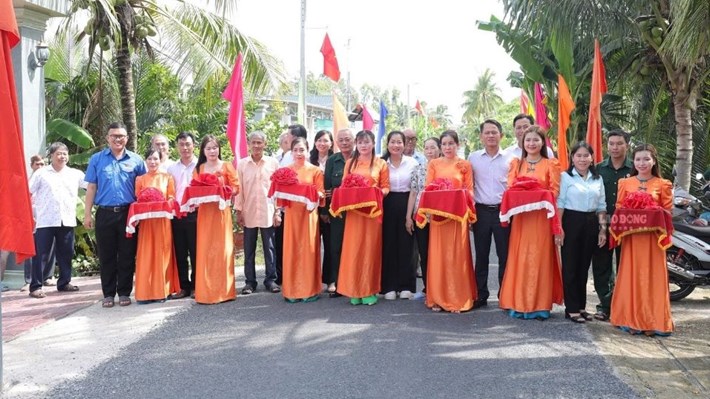 Lãnh đạo Hội Cựu chiến binh tỉnh Vĩnh Long và địa phương cắt băng khánh thành tuyến đèn đường gắn đường cờ Tổ quốc tại xã Trà Côn. Ảnh: Hoàng Lộc
