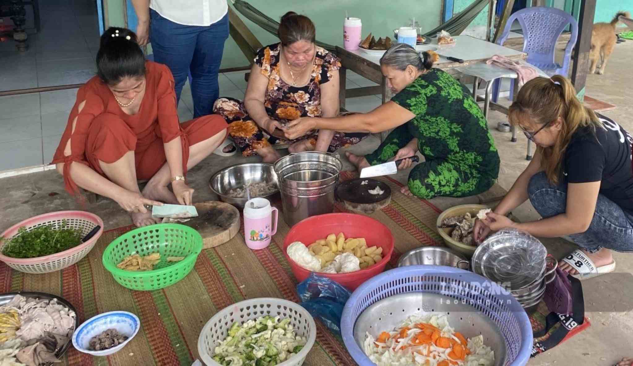 Gia đình chị Tâm quây quần bên nhau vừa trò chuyện vừa nấu ăn. Ảnh: Hân Nghiên