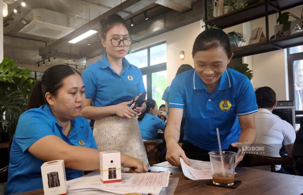 Cán bộ Công đoàn phường Hoà Khánh tranh thủ giải quyết công việc ngay bàn cà phê. Ảnh: Tường Minh