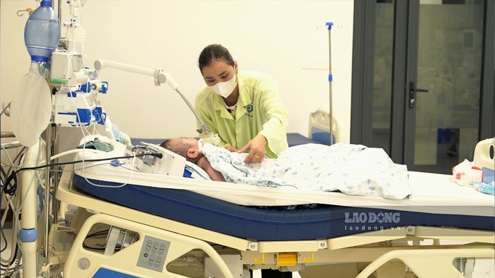 Profitant du week-end, Mme Phan Thị Việt Chinh est retournée à l'hôpital pour s'occuper de son enfant atteint de paralysie cérébrale. Photo: Linh Anh