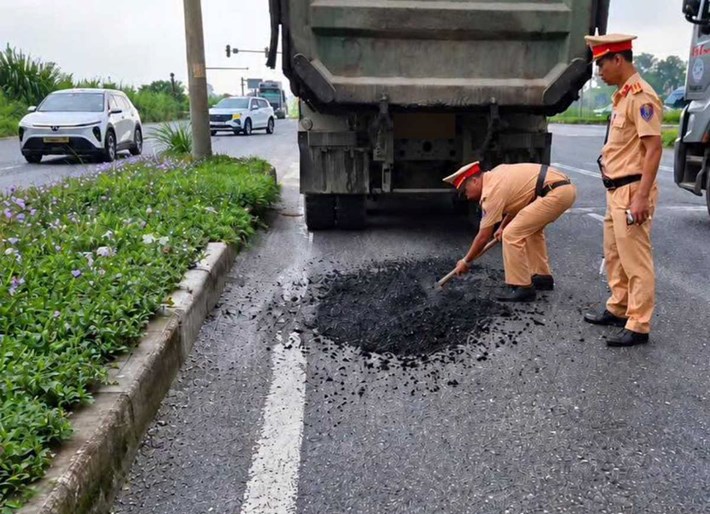 Đội CSGT đường bộ số 2, Phòng CSGT Công an tỉnh Ninh Bình sửa chữa đoạn đường bị hư hỏng. Ảnh: Công an tỉnh Ninh Bình