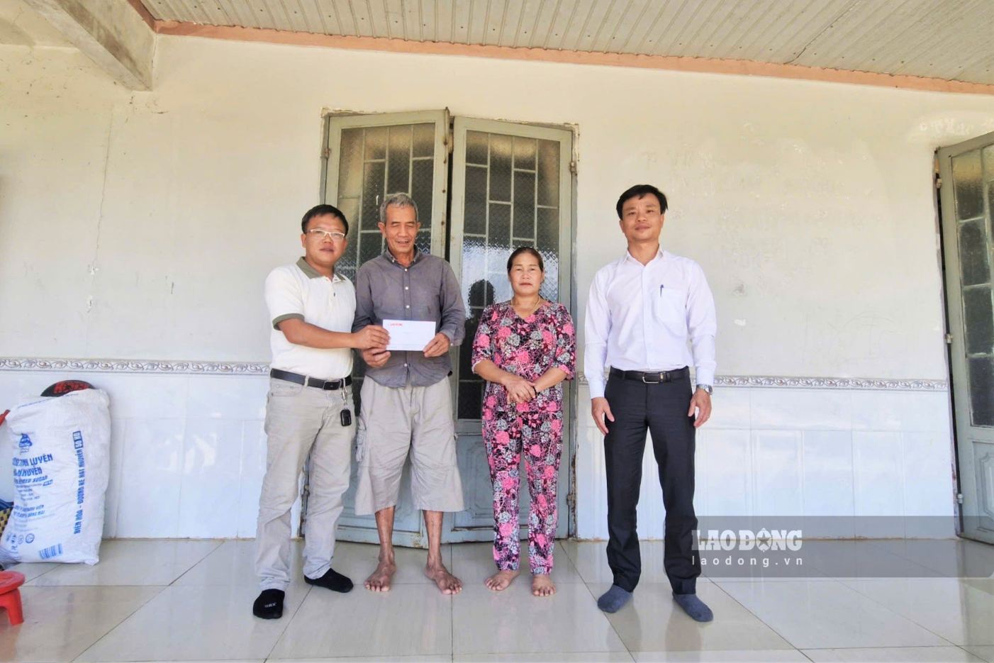 Phóng viên Phúc Khánh - đại diện Văn phòng Tây Nguyên Báo Lao Động (bìa trái) cùng lãnh đạo xã Bảo Lâm 2 trao số tiền 10 triệu đồng từ Quỹ Tấm lòng Vàng Lao Động cho gia đình 2 cháu Nguyễn Quang Vinh và Nguyễn Minh Quang. Ảnh: Hoài Thanh (chụp ngày 29.9) 