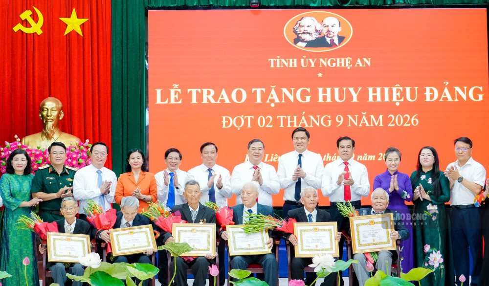 Các đồng chí lãnh đạo Đảng, Nhà nước, tỉnh Nghệ An trao Huy hiệu Đảng và tặng hoa chúc mừng các đảng viên lão thành. Ảnh: Duy Chương 