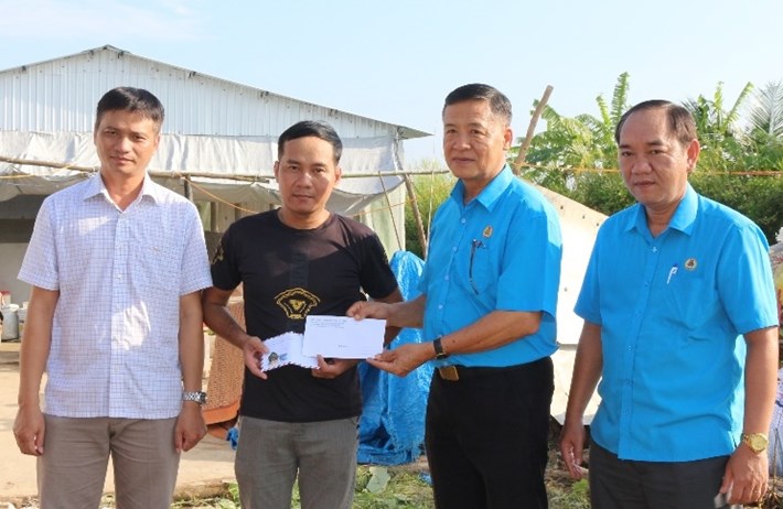 Phó Chủ tịch LĐLĐ tỉnh Cà Mau Huỳnh Văn Đậm (thứ 2, phải sang) trao hỗ trợ cho đoàn viên Võ Hồng Lĩnh. Ảnh: Thiệu Vũ