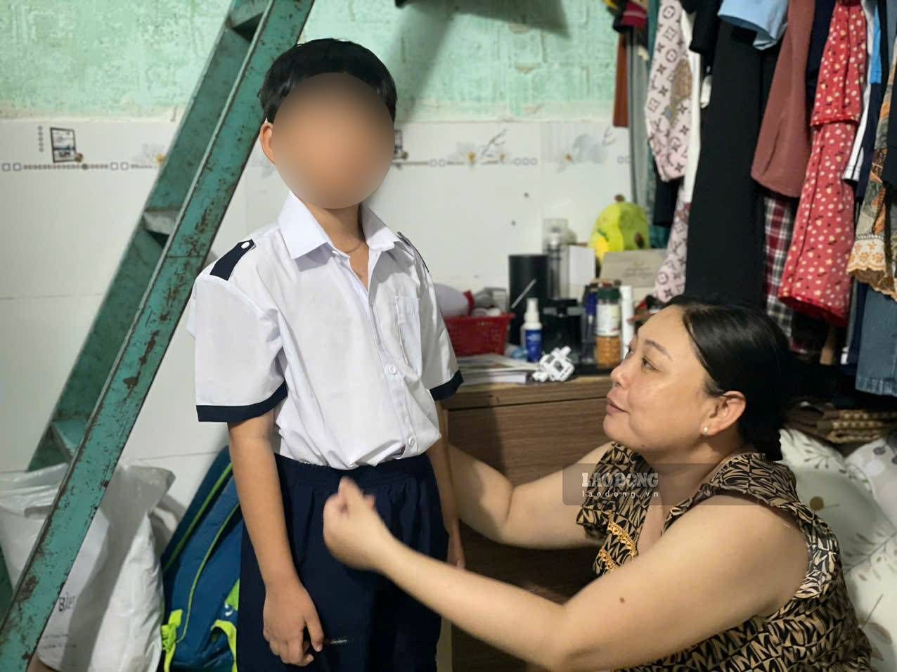 Chị Giàu sửa soạn lại quần áo cho con trai. Ảnh: Đình Trọng