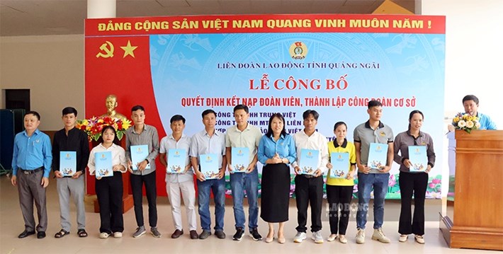 Bà Nguyễn Thị Việt Hiển - Phó Chủ tịch Liên đoàn Lao động tỉnh Quảng Ngãi (thứ 5 từ phải sang) trao Quyết định kết nạp đoàn viên. Ảnh: Quốc Chinh