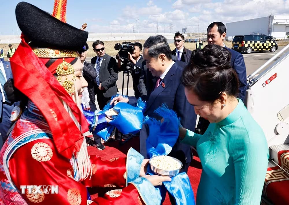 Hai thiếu nữ Mông Cổ tặng khăn Khadag và mời Ủy viên Bộ Chính trị, Chủ tịch Quốc hội Trần Thanh Mẫn và Phu nhân dùng bánh Aaruul theo nghi thức đón khách truyền thống của Mông Cổ. Ảnh: Doãn Tấn/TTXVN